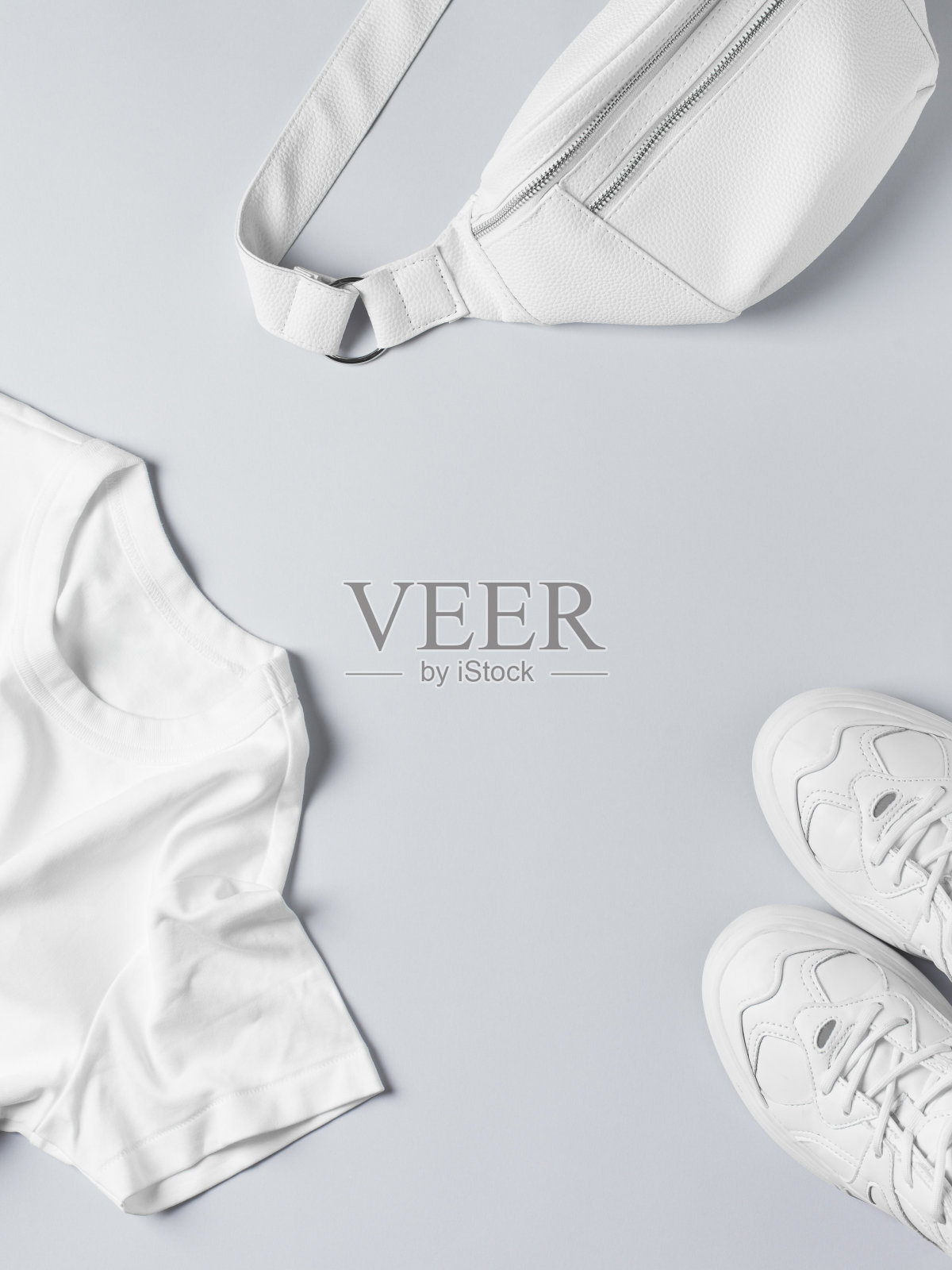 时尚平躺与白色t恤、运动鞋、腰包及配饰，单色概念，休闲外观。照片摄影图片