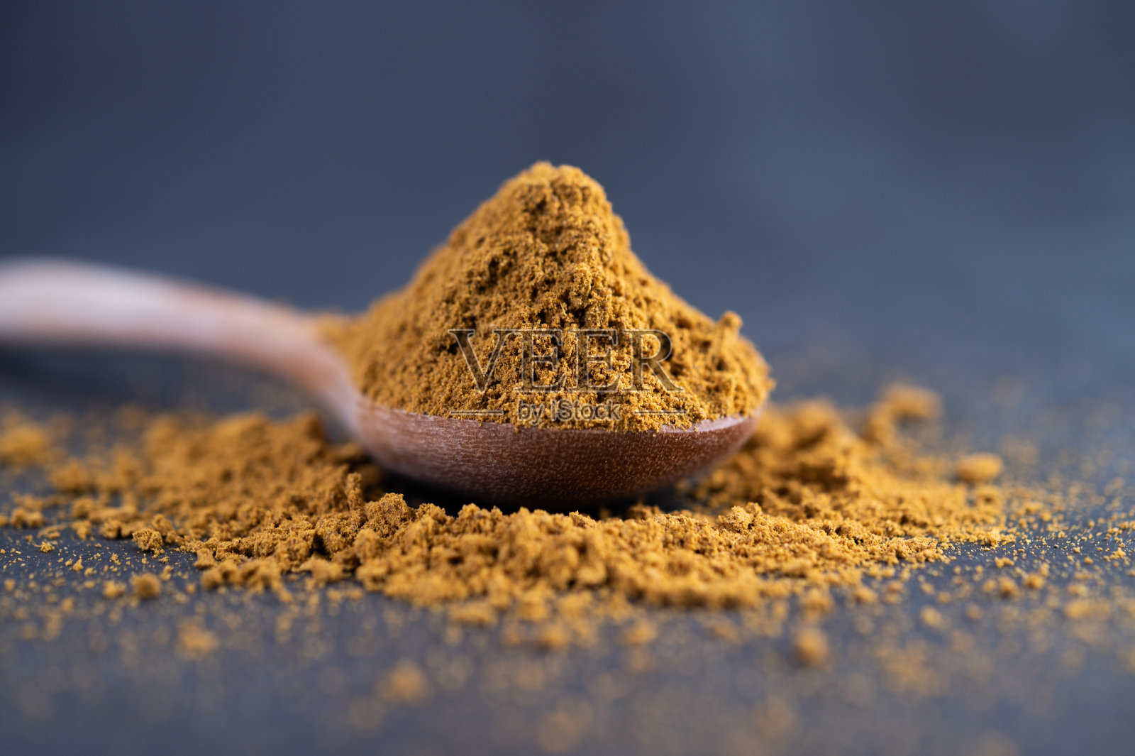 把香料放在勺子里，放在水泥地面上。有选择性的重点照片摄影图片