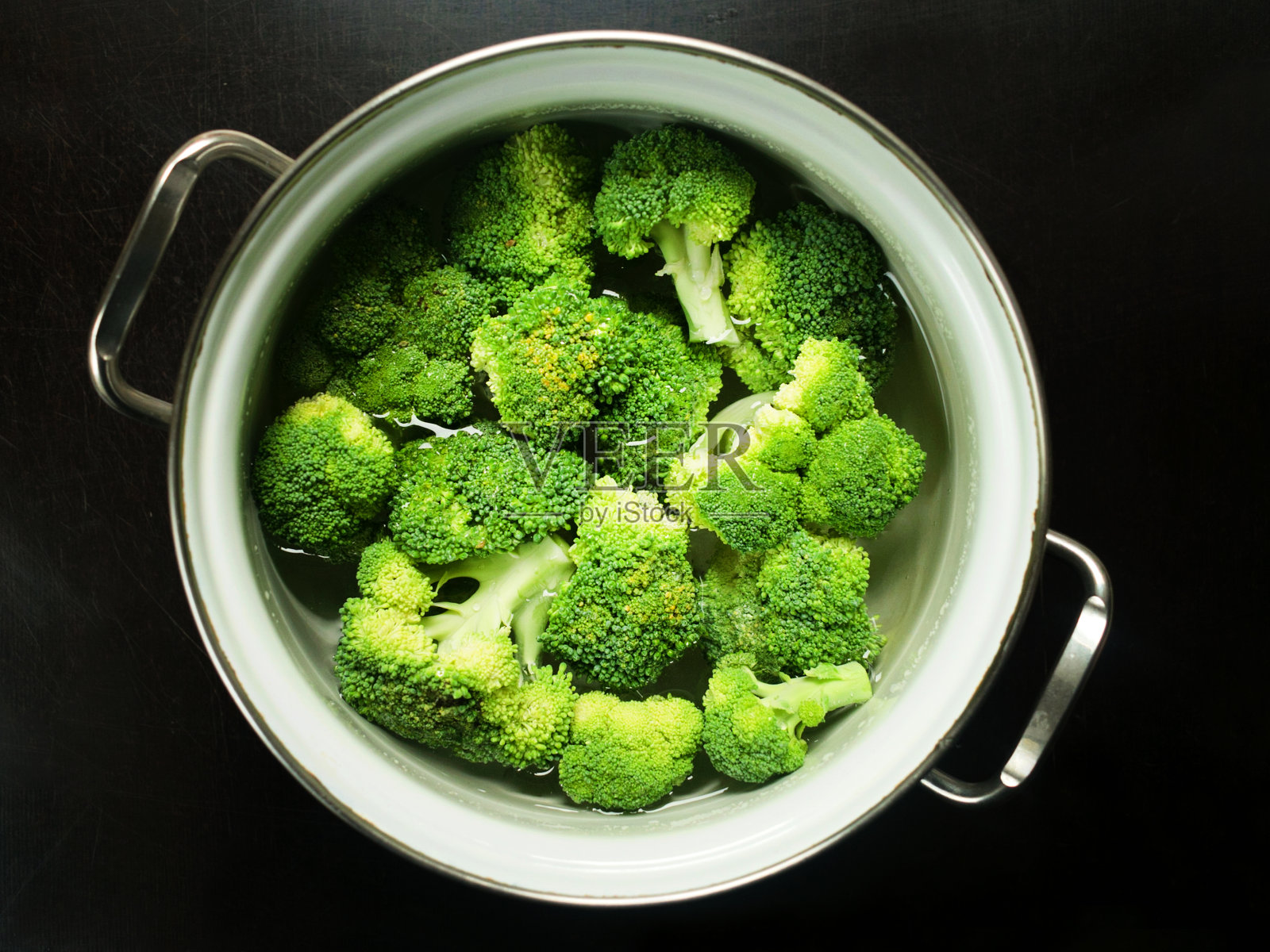 在平底锅中切花椰菜，背景为黑色。从以上观点。照片摄影图片