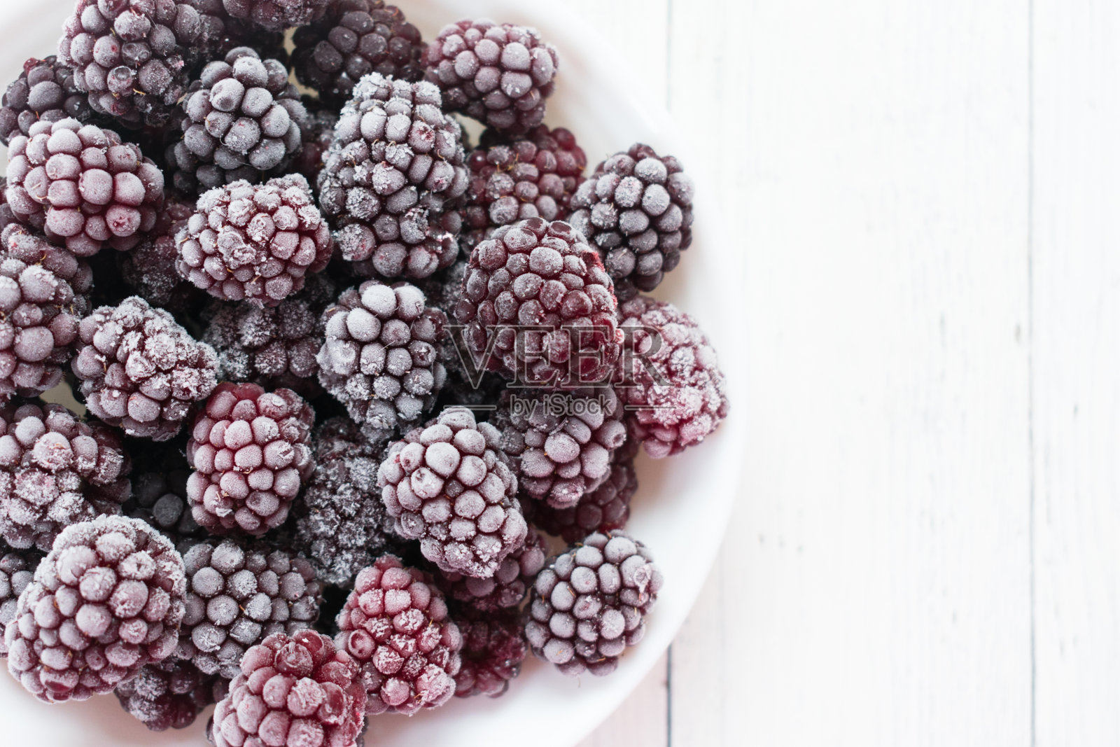 白色背景上的冰冻黑莓。照片摄影图片