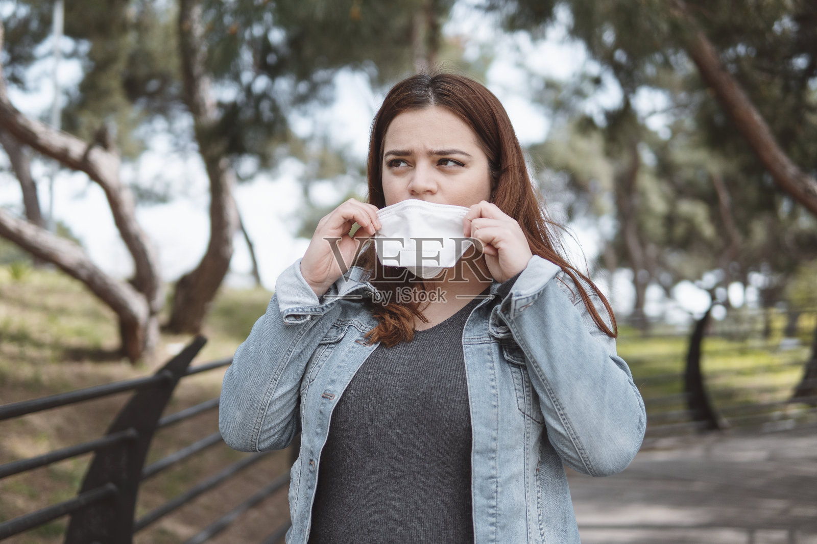 戴着口罩的年轻女子在公园里照片摄影图片