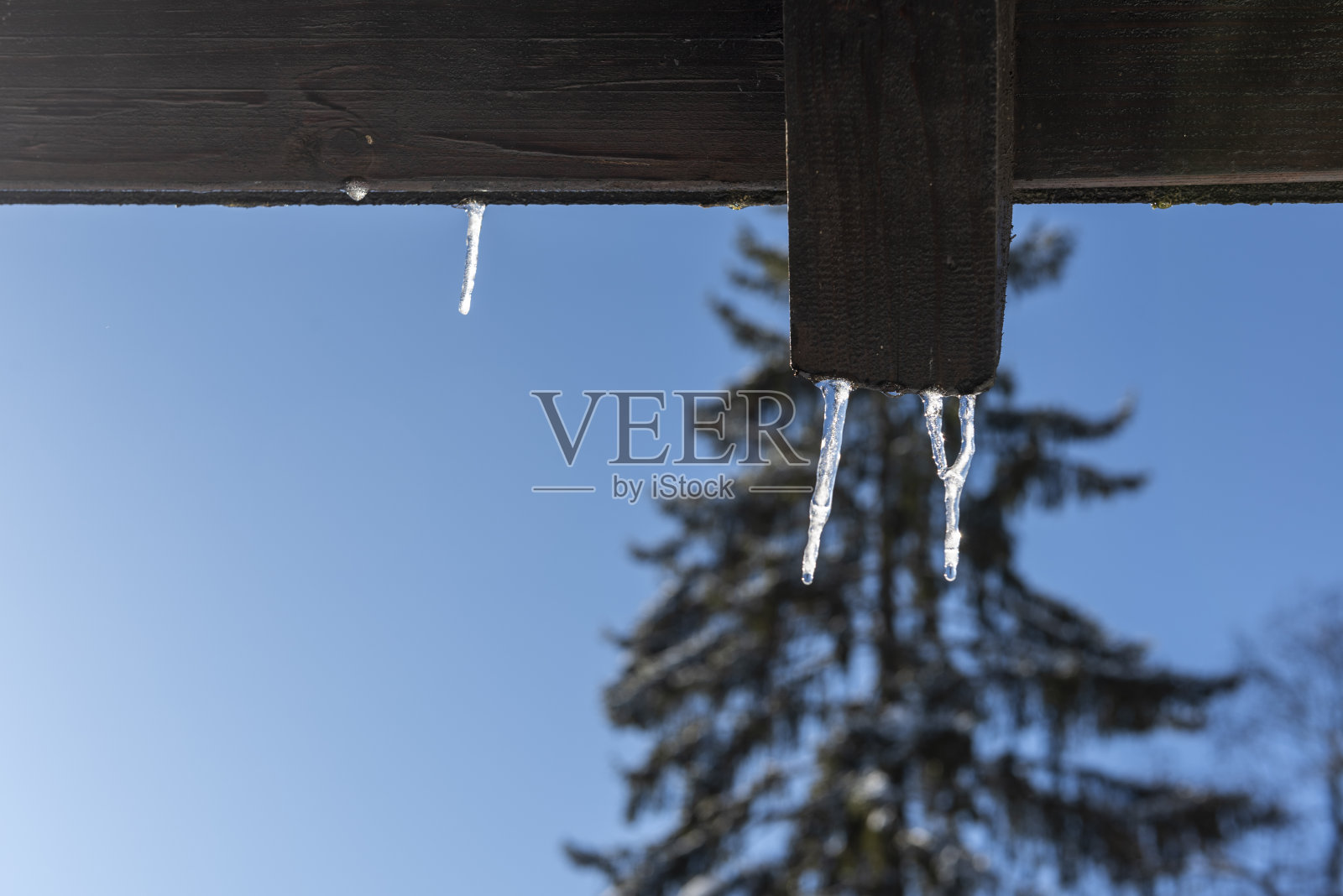 冰柱和水滴从建筑物的屋顶上挂下来照片摄影图片