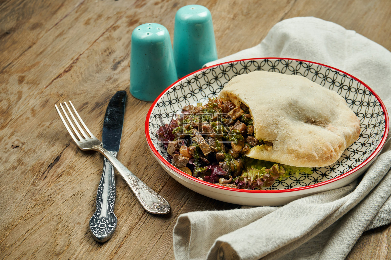 美味的街头小吃-皮塔与西红柿，黄瓜和牛肉在蓝色的木背景。希腊菜。关闭视图。Shwarma照片摄影图片