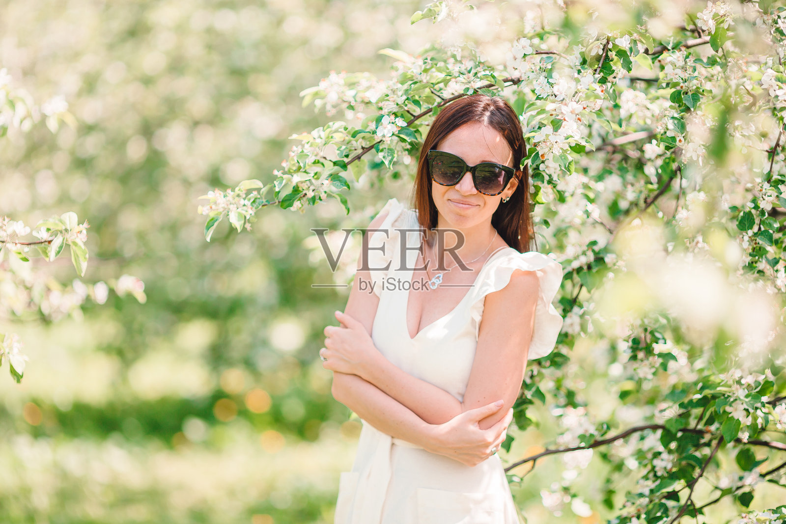 美丽女人在春日樱花园中享受花香照片摄影图片