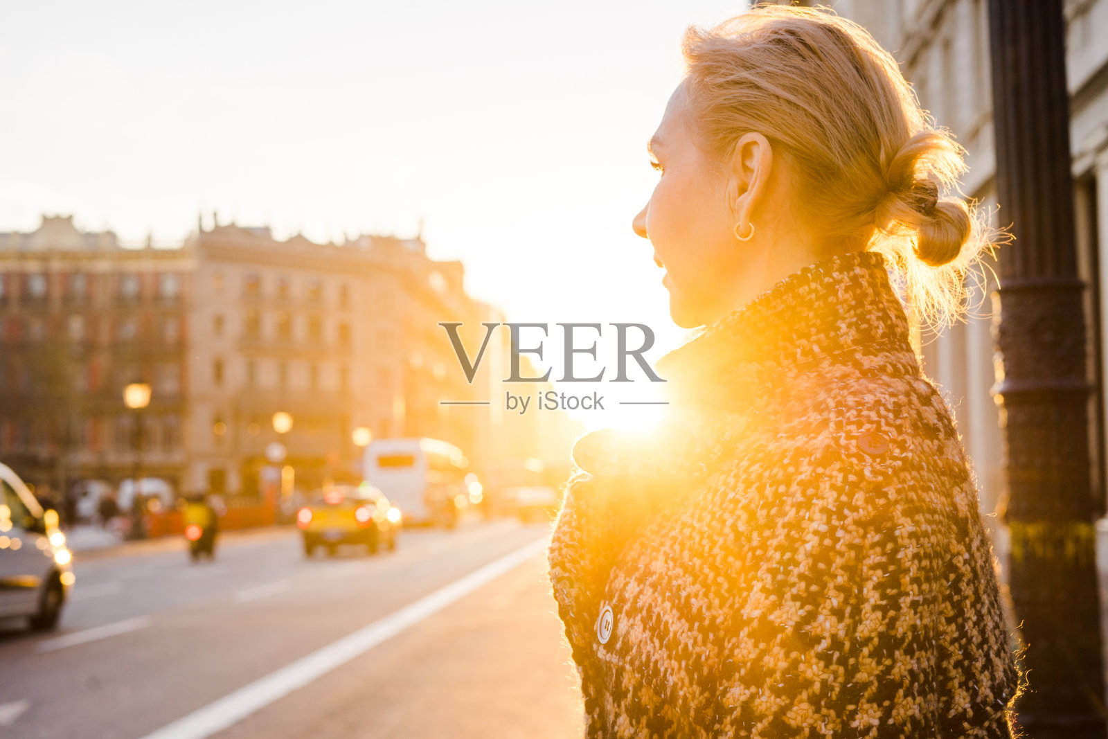 夕阳下站在街上望向远方的成年女人照片摄影图片