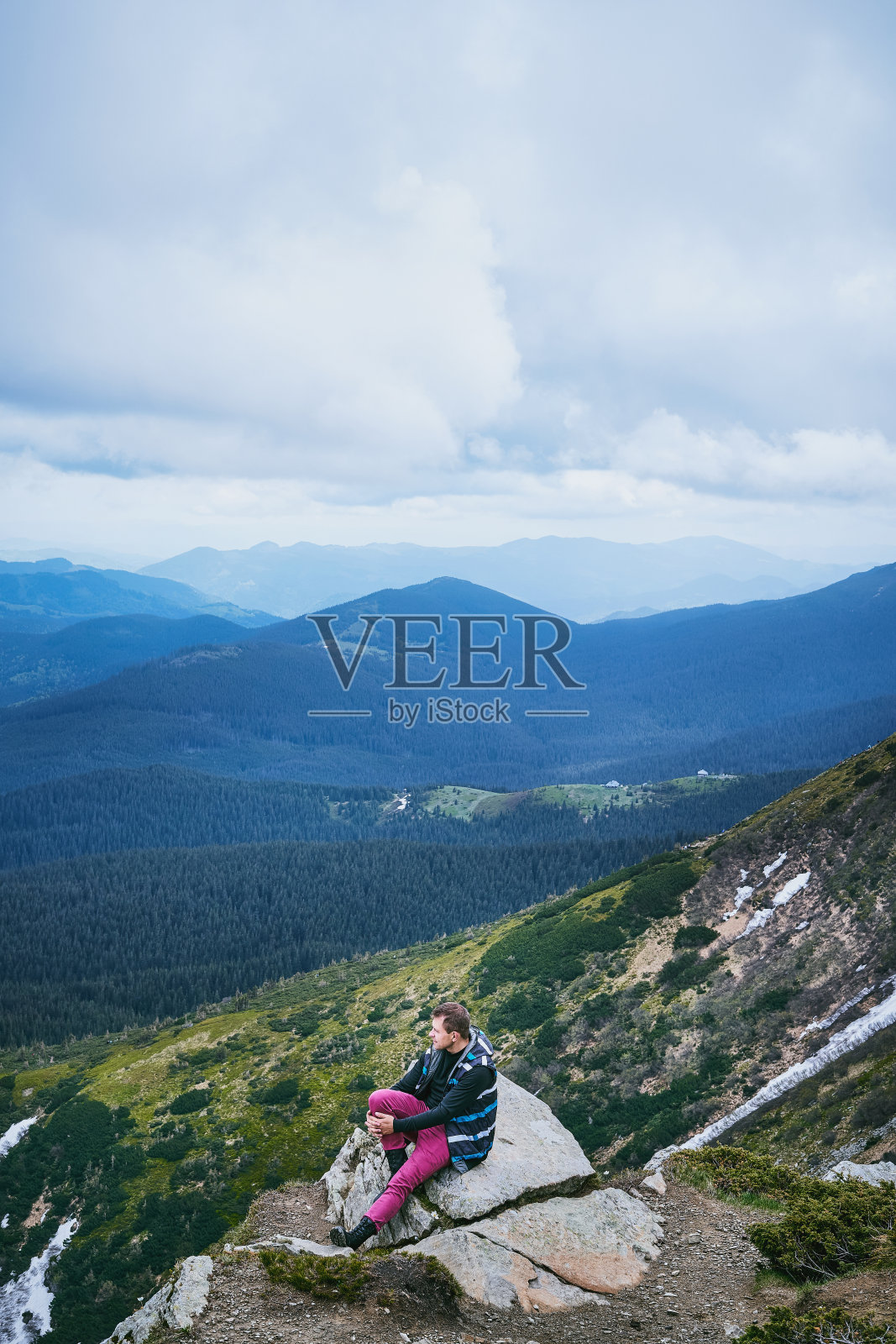 坐在山顶欣赏美丽风景的年轻徒步游客照片摄影图片