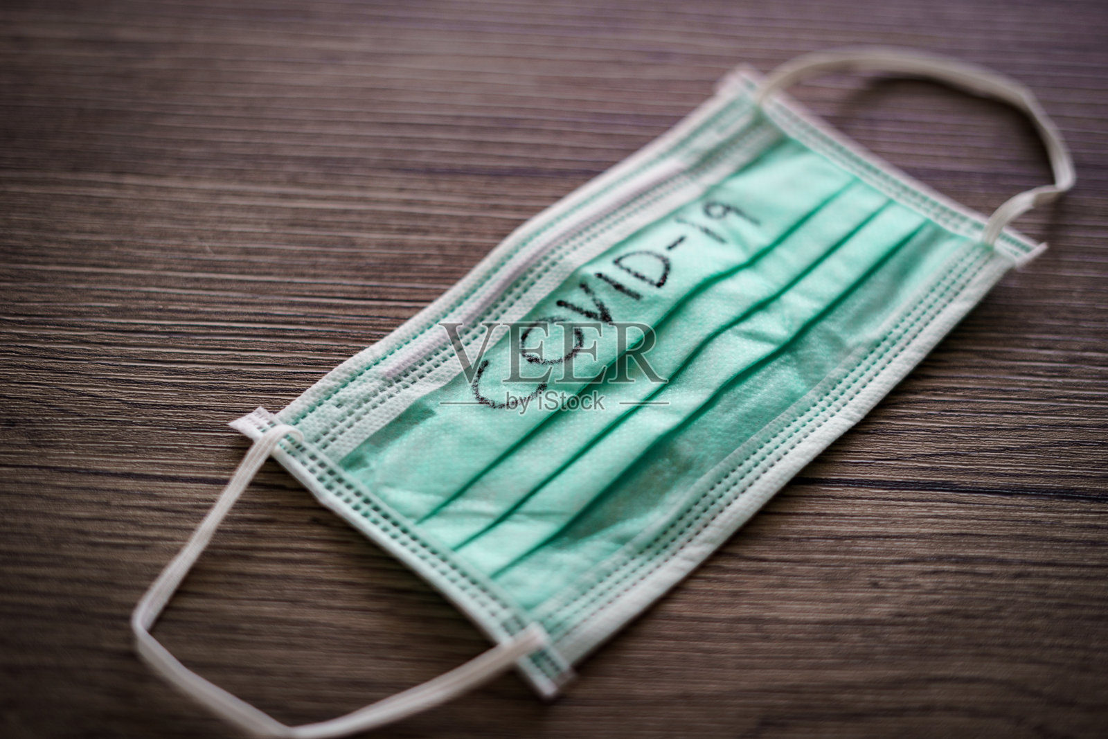 医用口罩冠状病毒(covid-19)文字书写。照片摄影图片