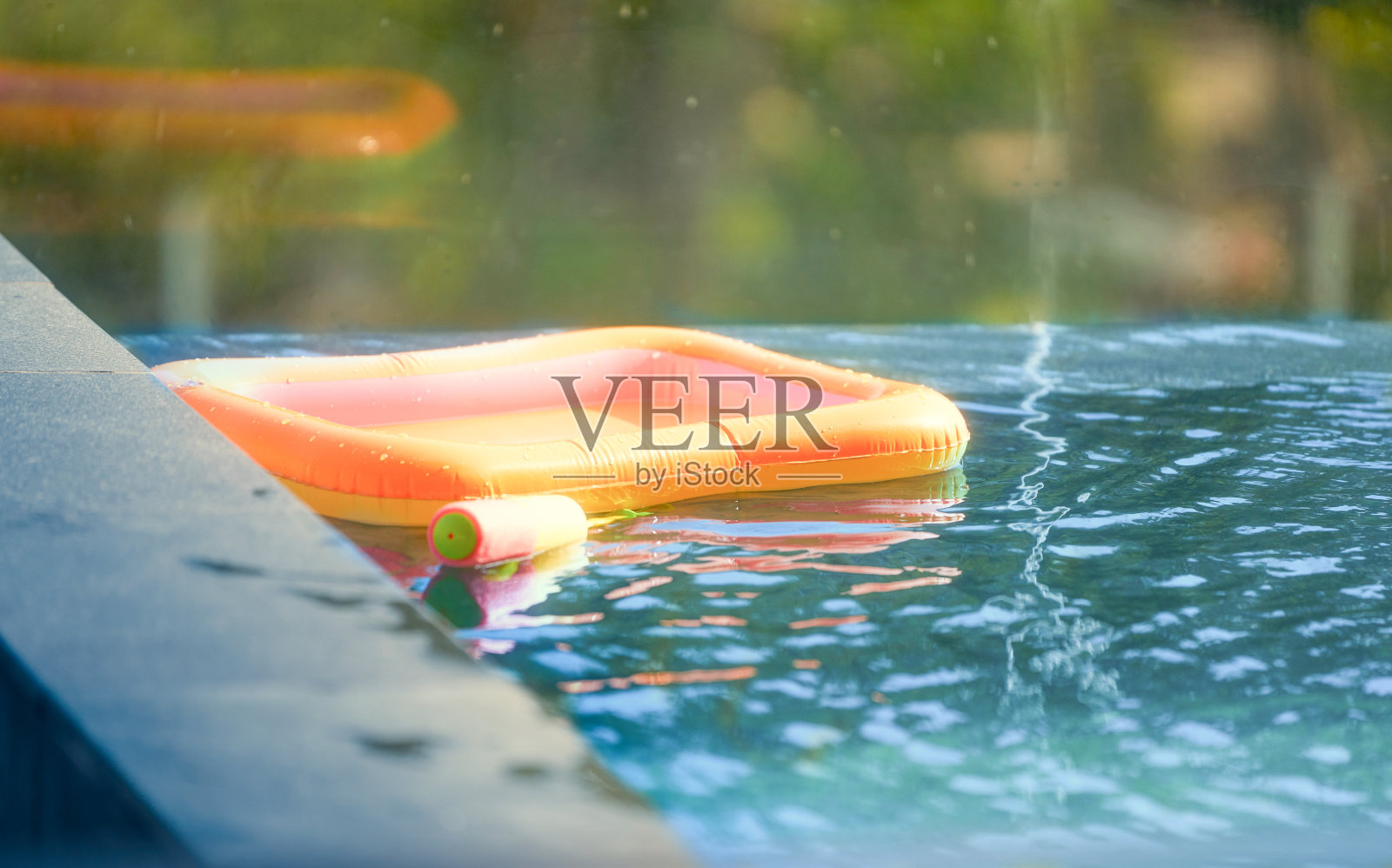 水枪和充气在水面上的蓝色游泳池在泼水节暑假照片摄影图片