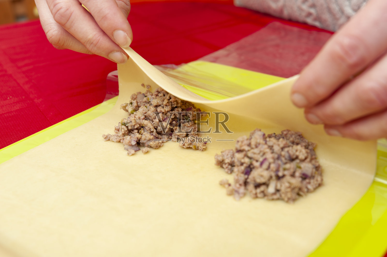 传统巴西食物“PASTEL”-女人的手滚动面团与碎牛肉。照片摄影图片