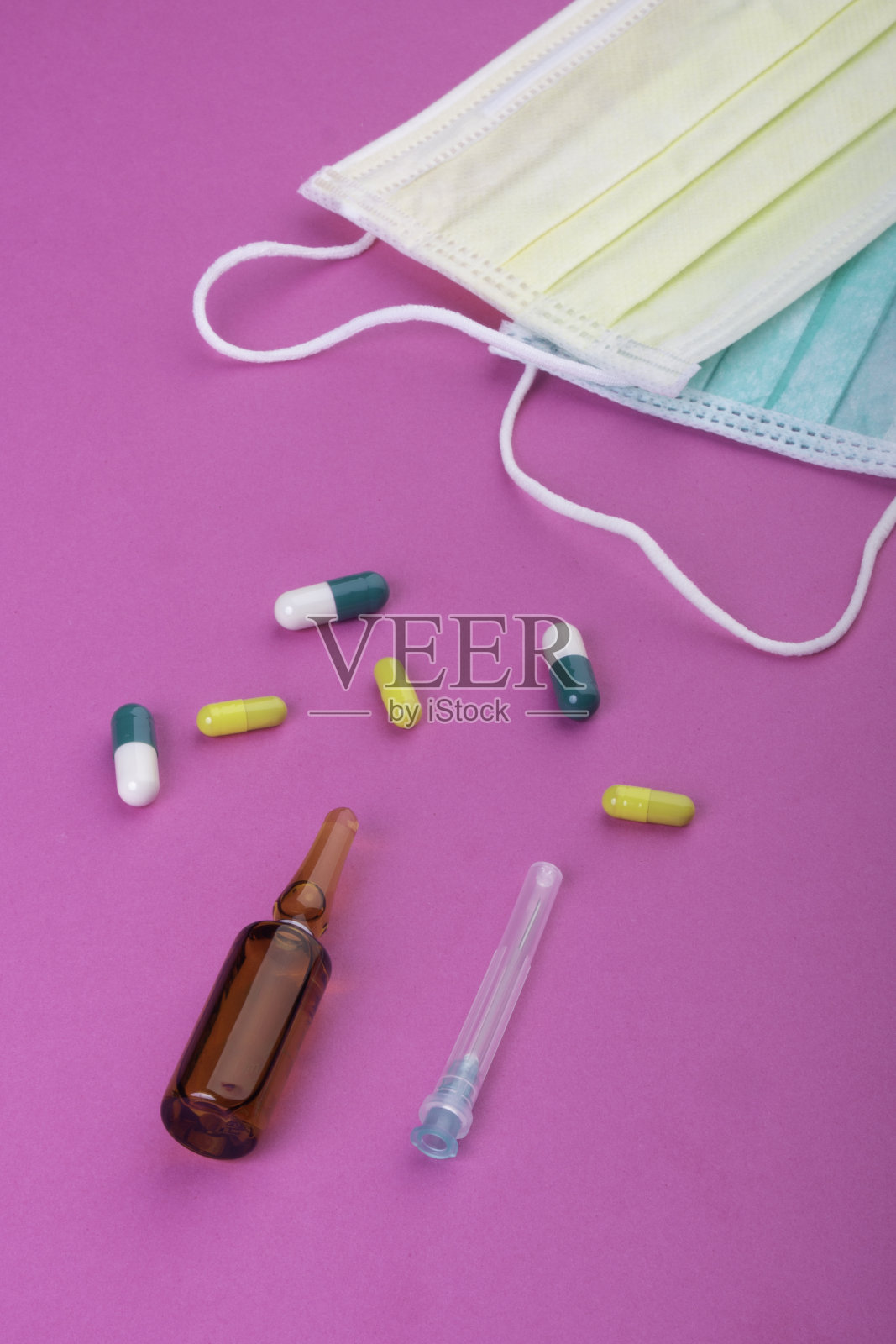 粉色背景防护面罩、药丸、针照片摄影图片