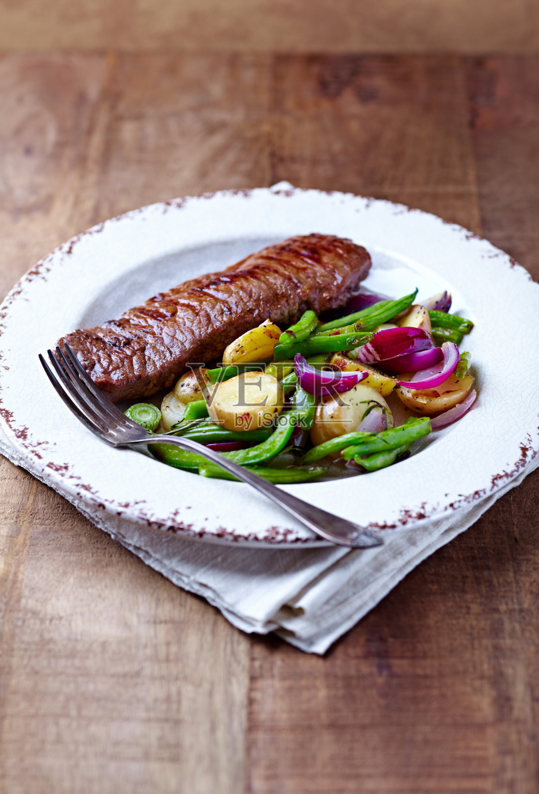 牛肉和烤箱烤蔬菜在乡村木制背景。照片摄影图片