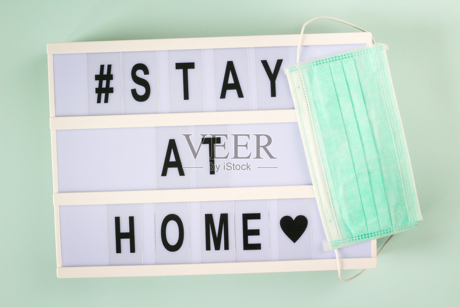 冠状病毒大流行全球信息“待在家里”灯箱上。2019冠状病毒病的自我隔离、预防和保健理念。照片摄影图片