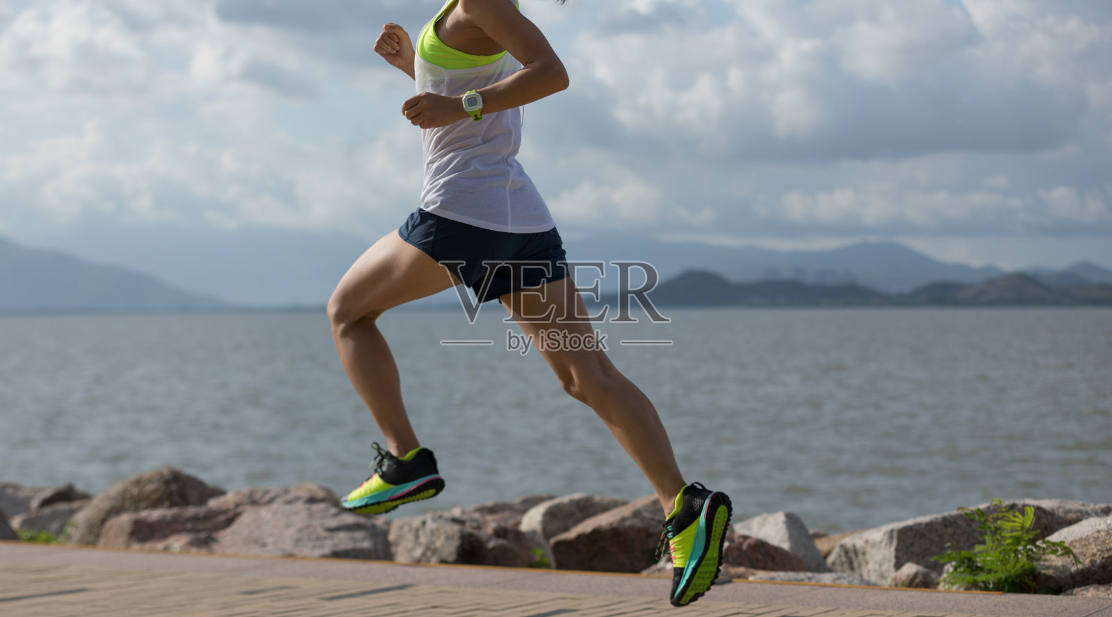 健身女人在阳光明媚的海岸小径上进行马拉松跑步训练照片摄影图片