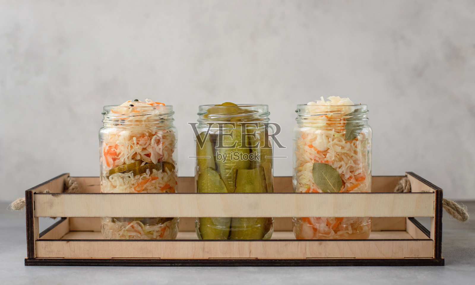 自制的腌白菜和黄瓜装在一个木盒子里。照片摄影图片