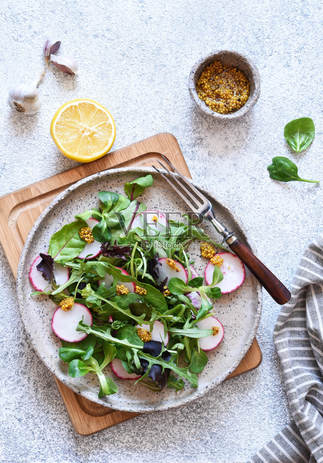 把色拉与萝卜和芥末酱混合。沙拉在餐桌上。从以上观点。照片摄影图片