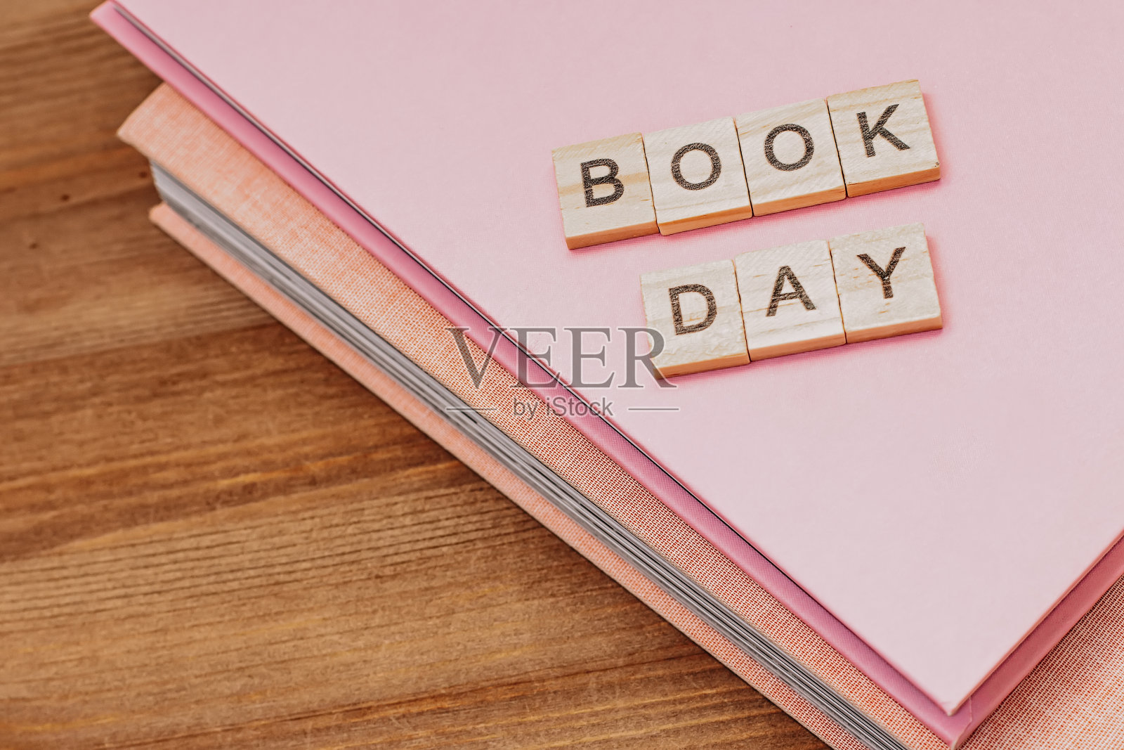 单词世界读书日由带黑眼镜的木块和成堆的书组成。图书假期的背景照片摄影图片