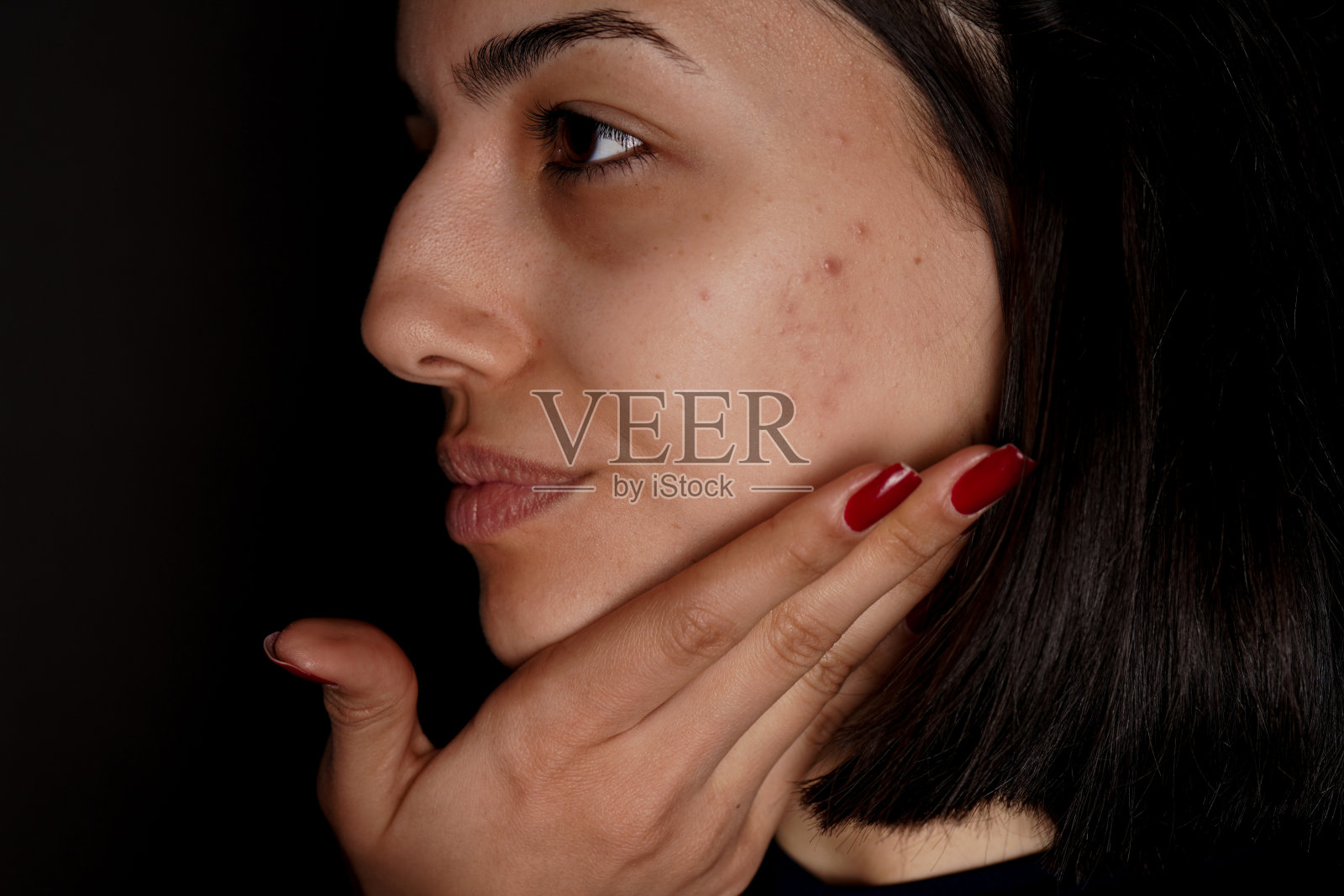 年轻女子在脸上涂遮瑕膏照片摄影图片