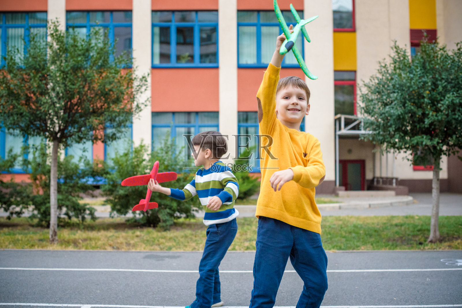 快乐的两个兄弟孩子在蓝天下玩玩具飞机。照片摄影图片