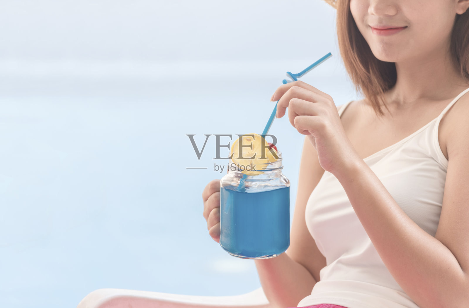 健康的软饮料健康的生活方式与年轻快乐的女人喝蓝色夏威夷新鲜成分有机果汁。美丽的女人拿着杯子，面带微笑，健康饮食，喝着水。照片摄影图片