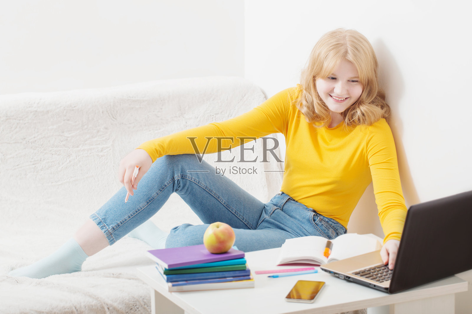 十几岁的女孩在家里用笔记本学习。在线教育,电子学习。照片摄影图片