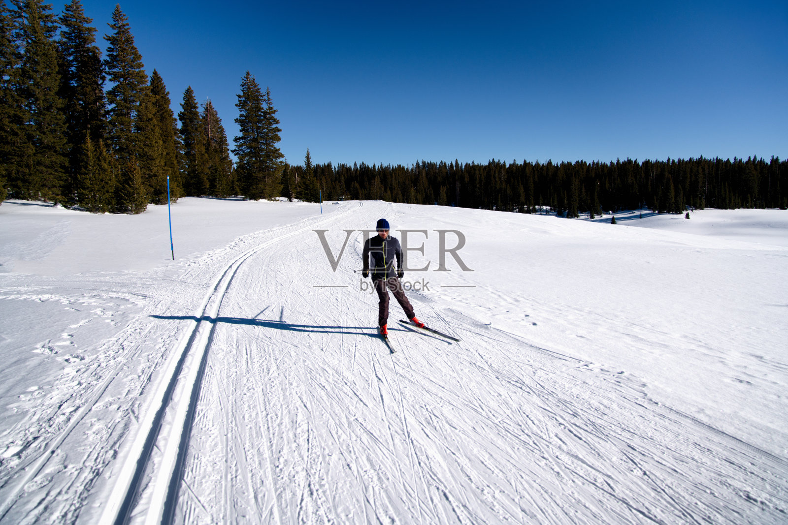 男子在晴朗的一天进行越野滑雪照片摄影图片