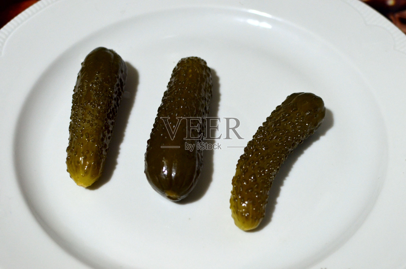 腌黄瓜放在白盘子里照片摄影图片