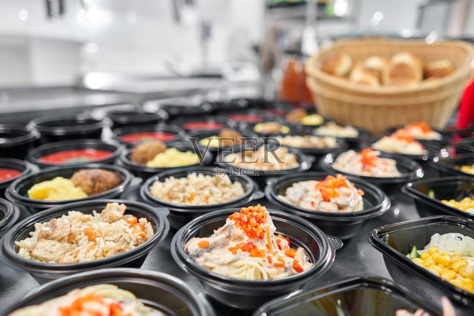 一排塑料一次性饭盒，内含健康天然食品。汤，奶油汤，主菜配菜，沙拉。食品交付。在办公室吃午餐。照片摄影图片