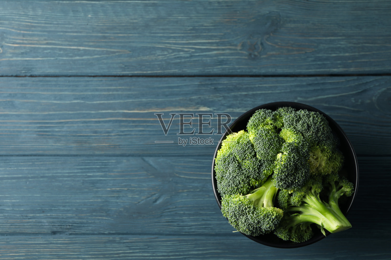 碗与西兰花木质背景，俯视图。健康的食物照片摄影图片