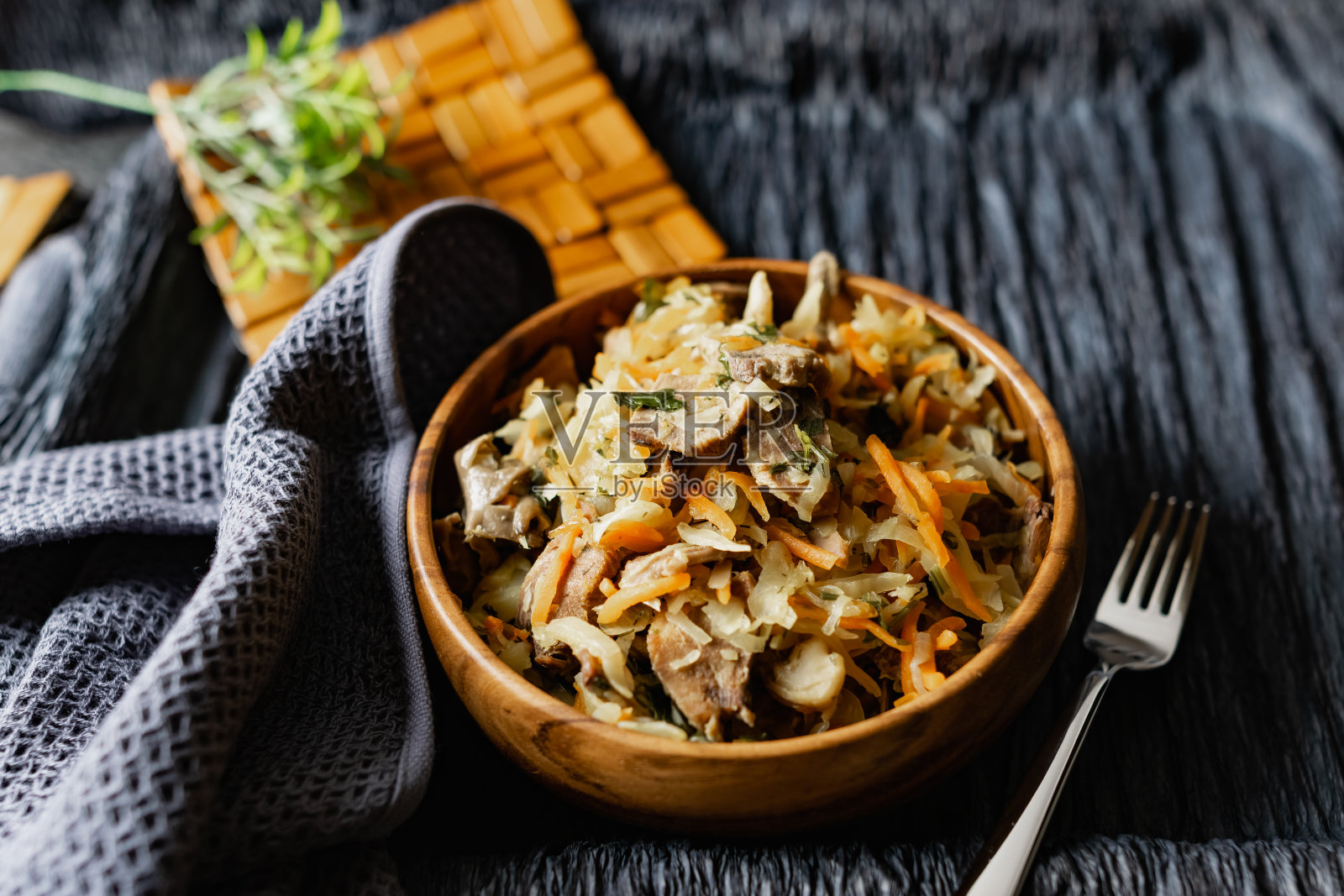 洋白菜配平菇，猪舌配胡萝卜和洋葱。木架子上的木盘子里的热菜照片摄影图片
