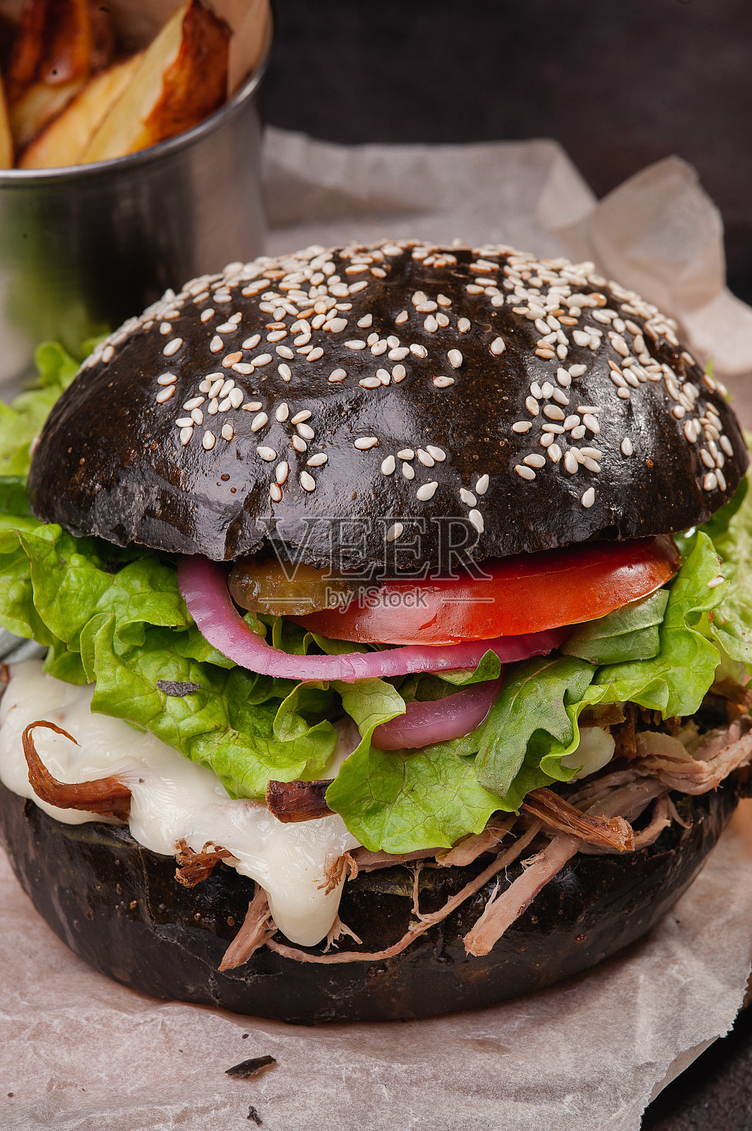 牛皮纸上的黑色肉馅汉堡。照片摄影图片