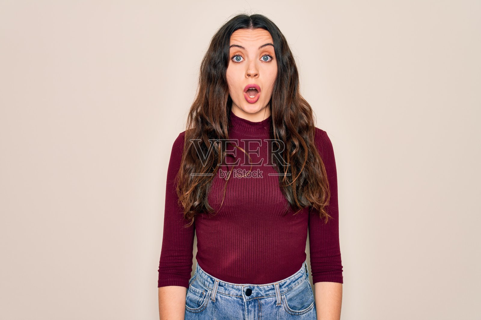 年轻美丽的女子穿着休闲t恤站在孤立的白色背景害怕和震惊与惊讶的表情，恐惧和兴奋的脸。照片摄影图片