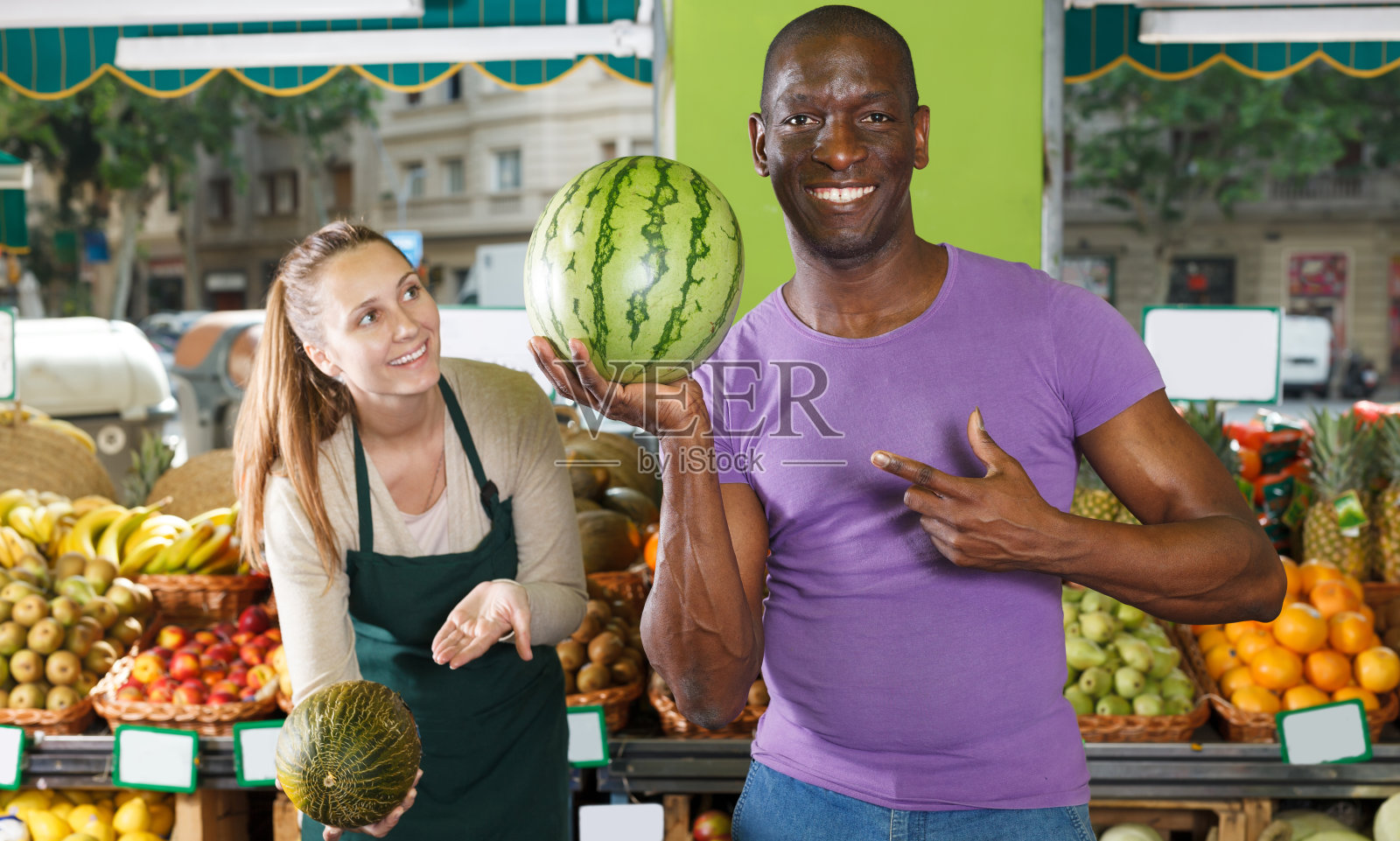 卖家与成年顾客拿着西瓜照片摄影图片