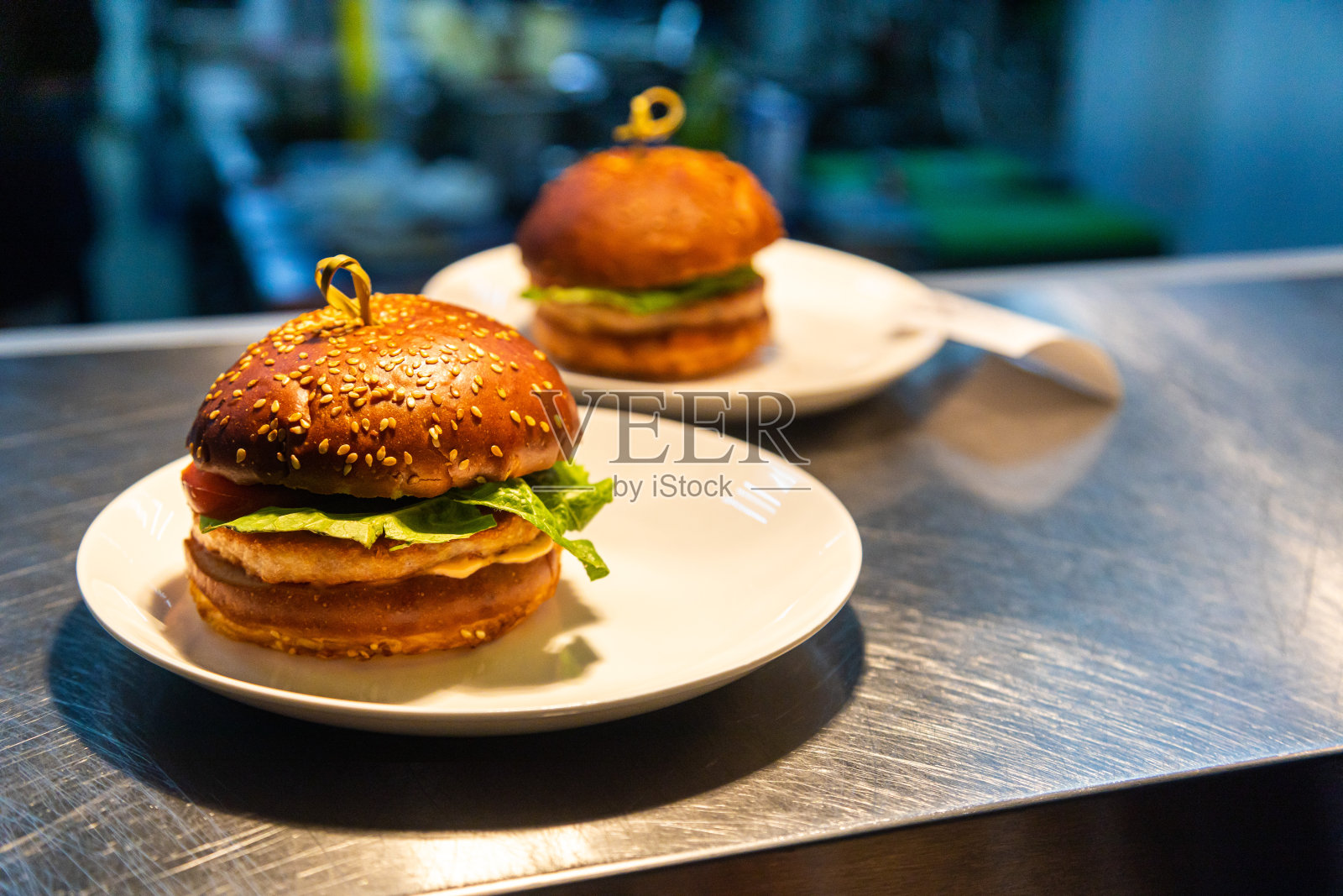 背景是餐厅和厨房柜台上供服务员享用的速食汉堡照片摄影图片