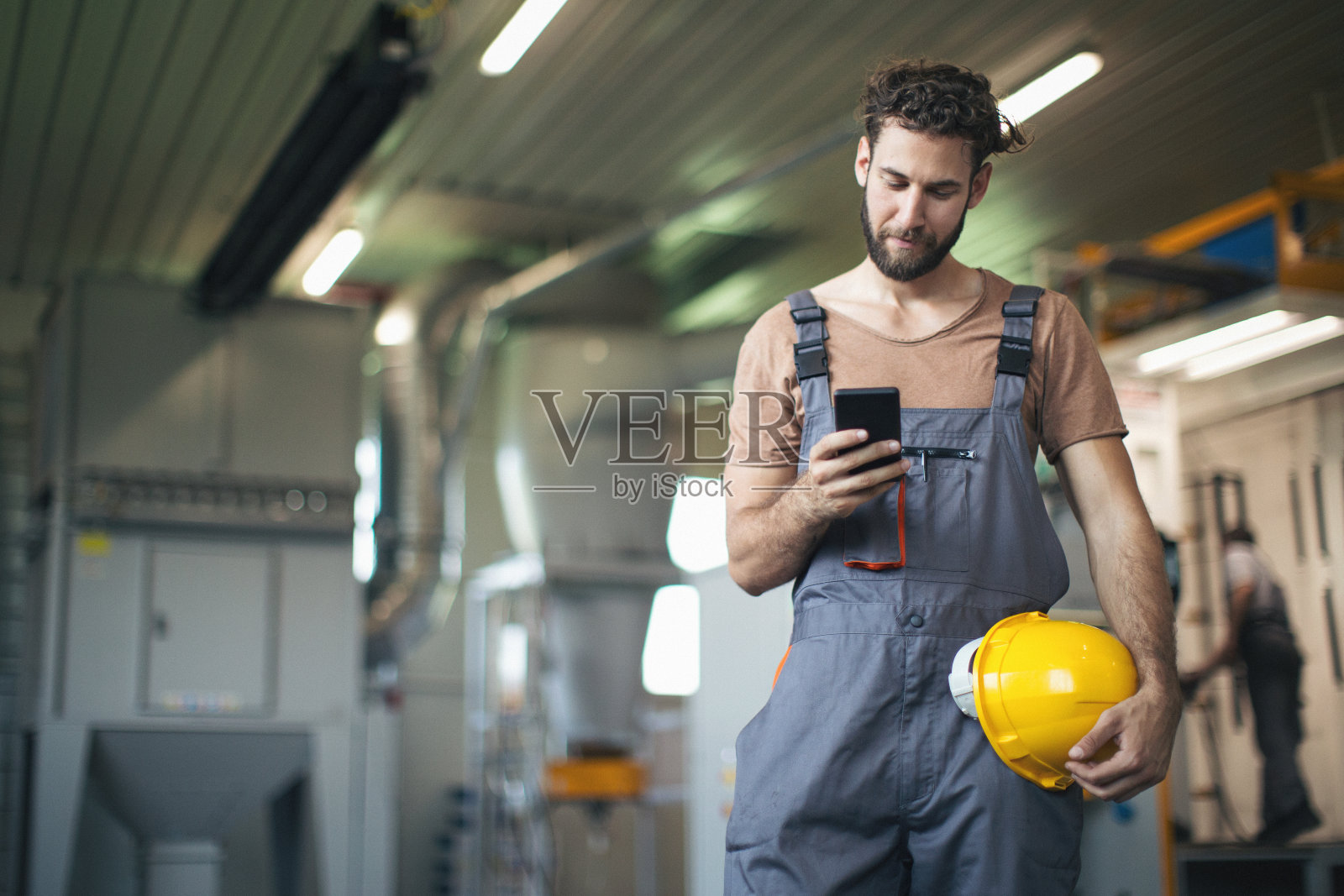 在工厂里使用和检查机器的年轻人照片摄影图片