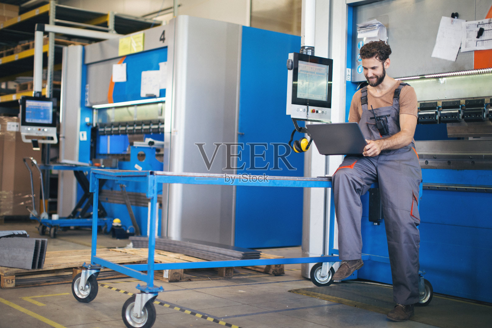 在工厂里使用和检查机器的年轻人照片摄影图片