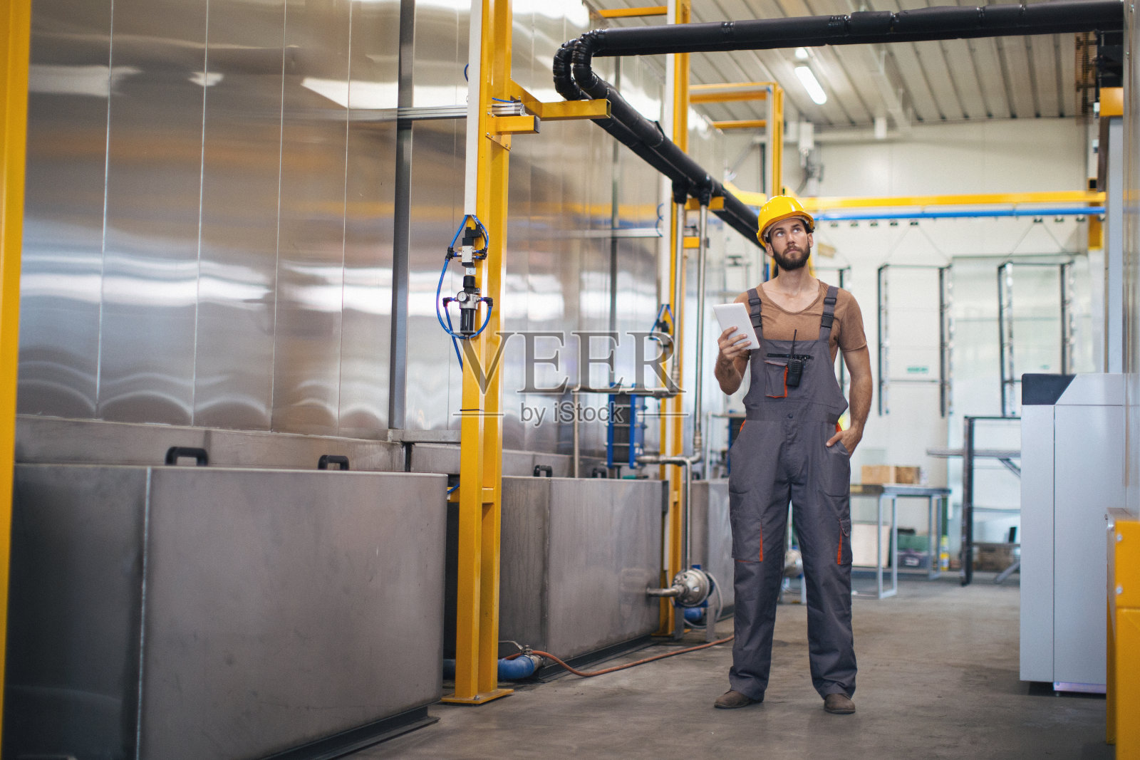 在工厂里使用和检查机器的年轻人照片摄影图片