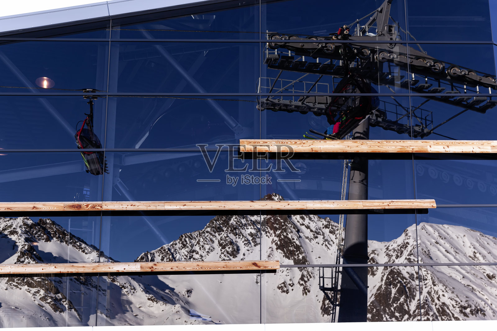 奥地利伊斯格尔——2020年1月:伊斯格尔滑雪胜地的Pardorama餐厅全景窗口中映出的山脉和缆车。白雪覆盖着山顶。照片摄影图片