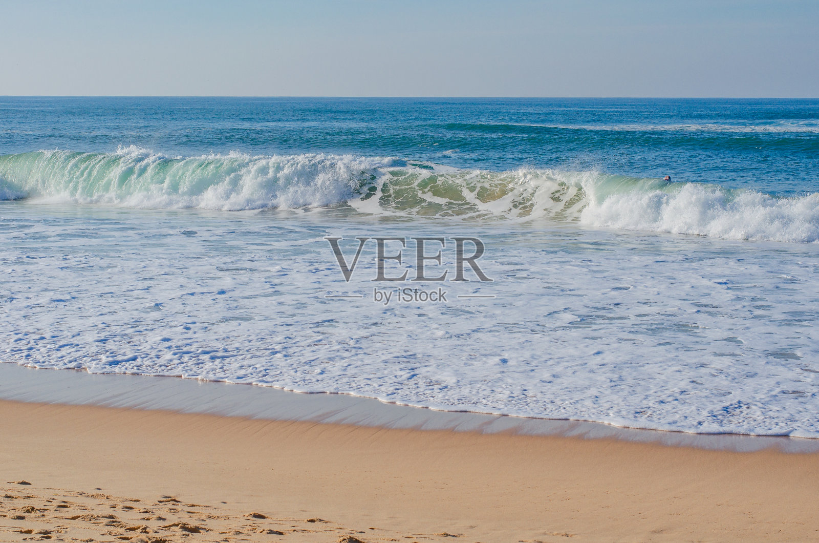 风景如画的葡萄牙海滩，海浪冲上岸。冲浪的好天气。照片摄影图片