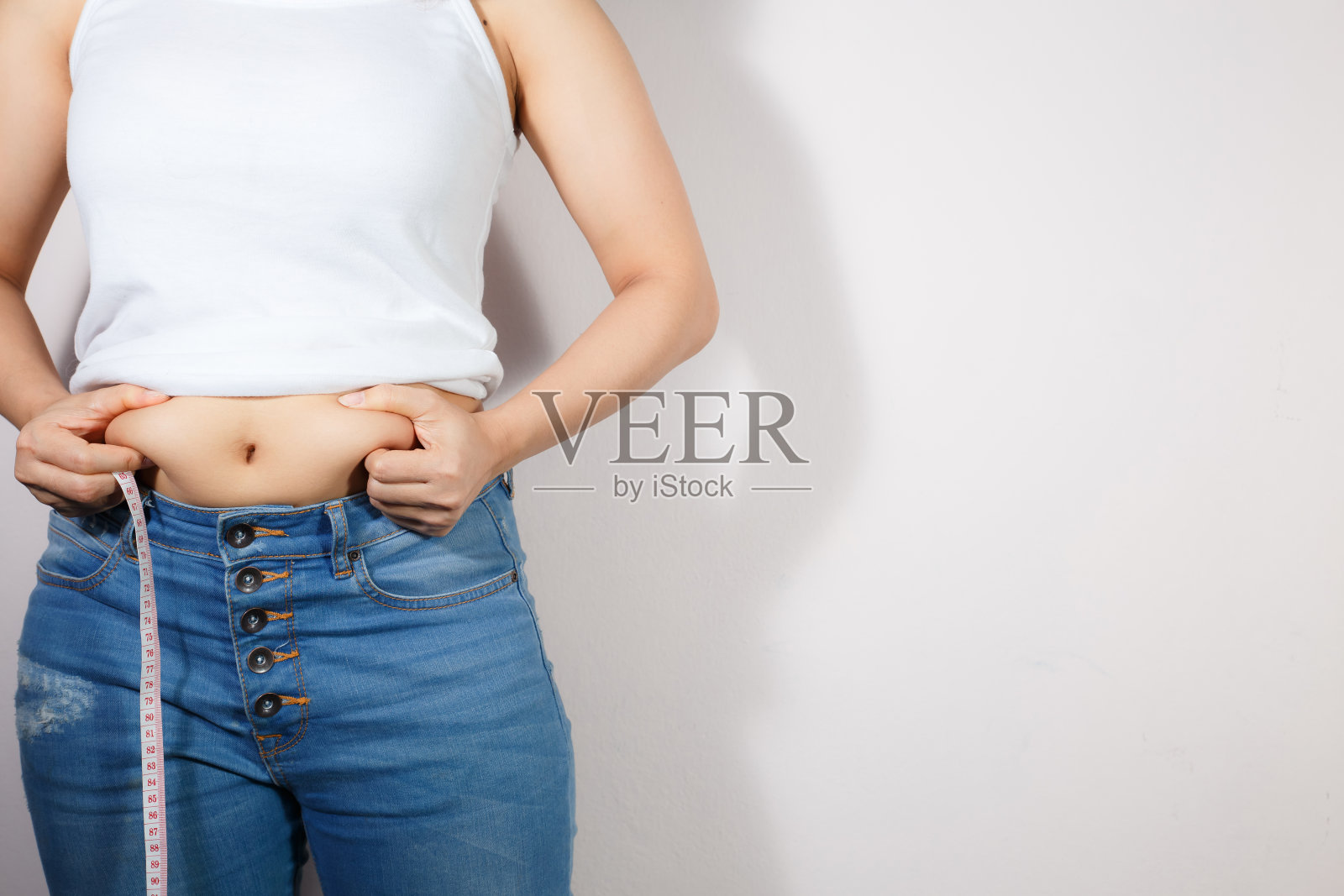 体型较胖的妇女，腹部肥胖，超重，白色背景，健康饮食概念，减少腹部脂肪，塑造健康腹部肌肉照片摄影图片