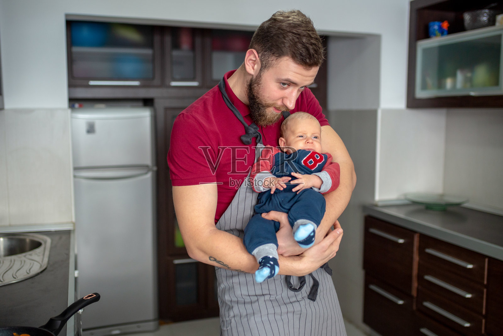 室内肖像，年轻的父亲拥抱他的小儿子在厨房照片摄影图片