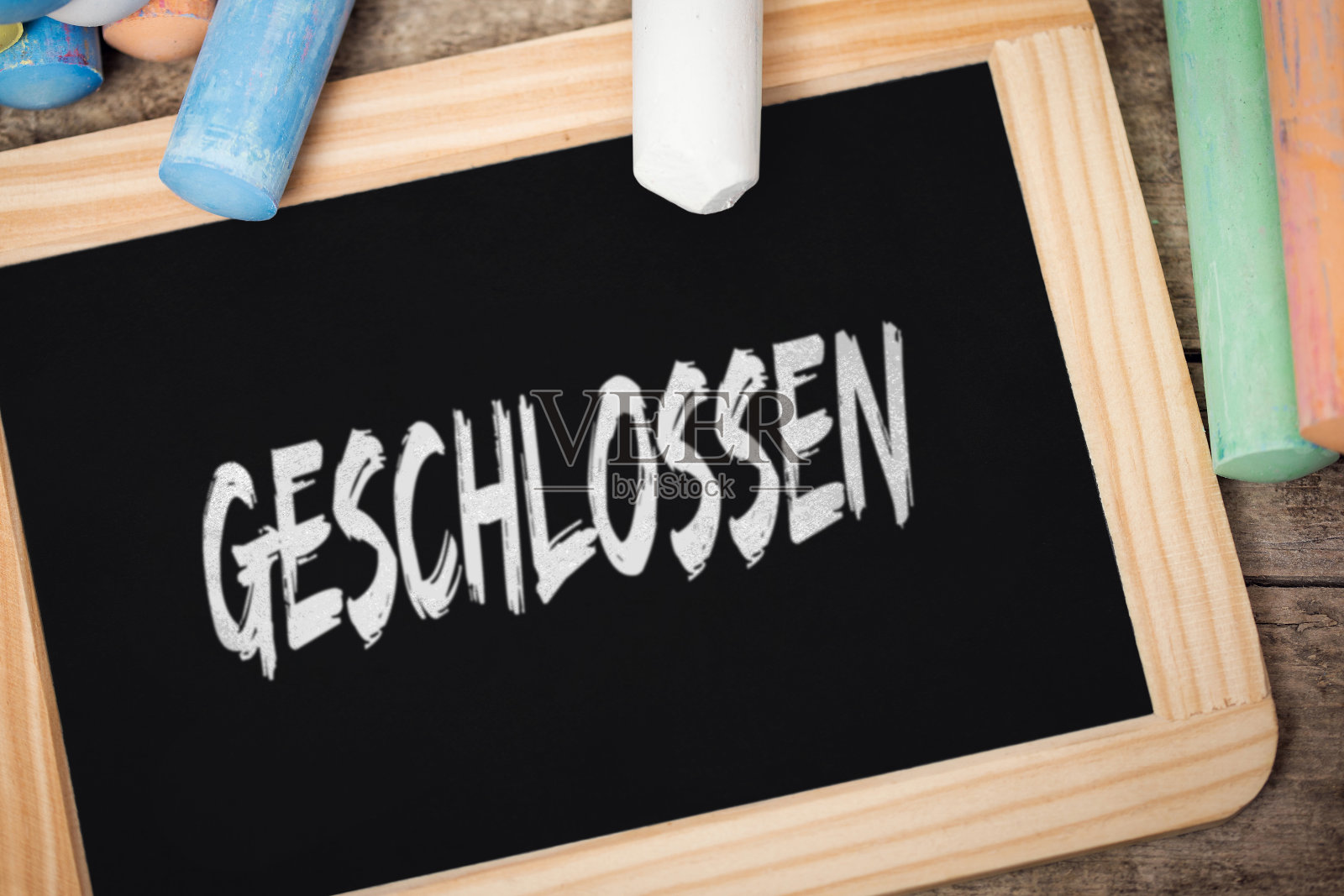 黑板上写着德语单词geschlossen，意思是封闭的、概念冠状病毒或covid-19病毒、幼儿园、托儿所和学校、大流行防疫用品照片摄影图片