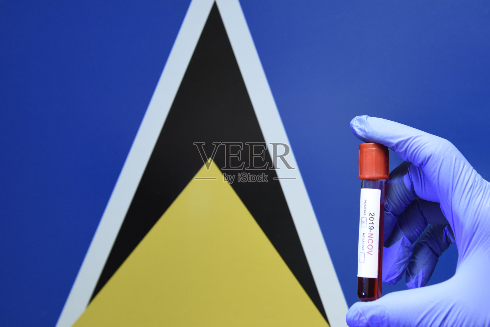 圣卢西亚新冠病毒血液样本，手持试管，国旗背景照片摄影图片