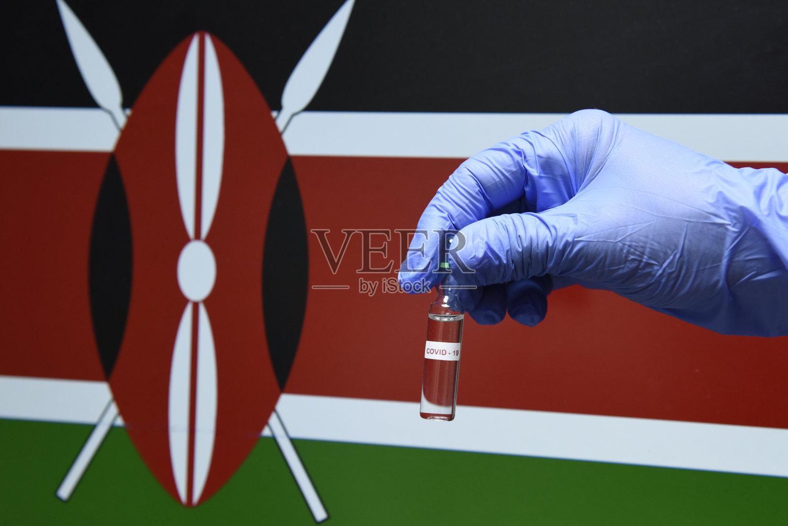 肯尼亚的冠状病毒或Covid-19，手持带有肯尼亚国旗背景的血液样本试管照片摄影图片