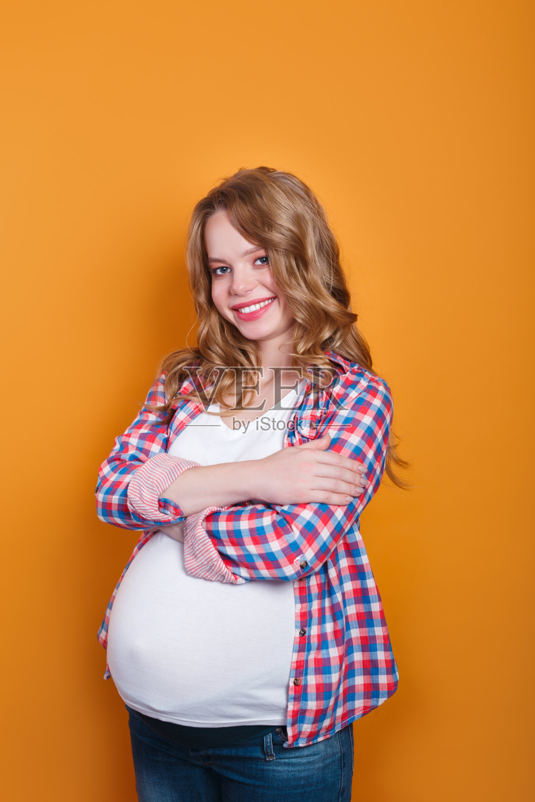 黄色背景上快乐的大肚子孕妇照片摄影图片