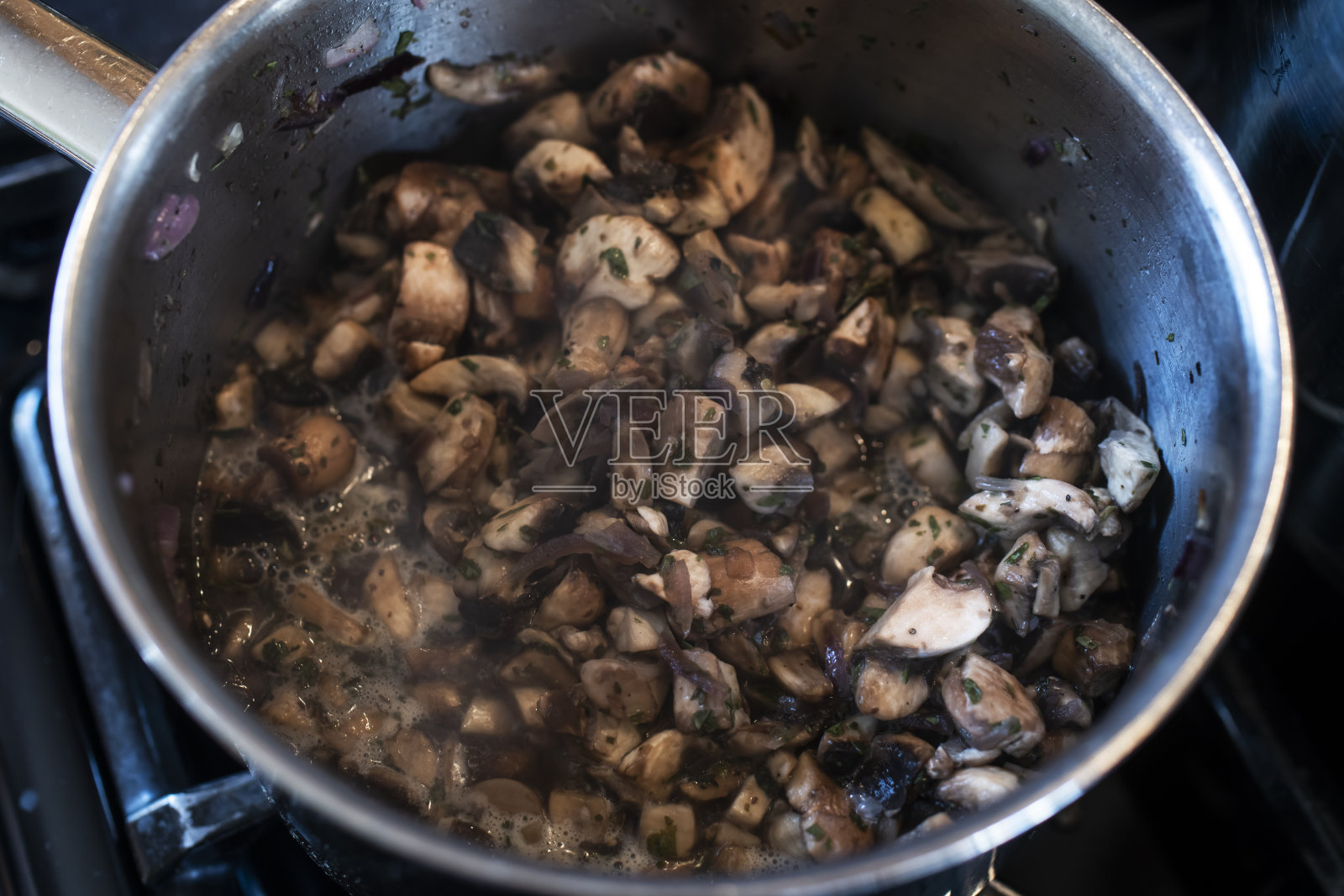 将蘑菇放入沸水中照片摄影图片