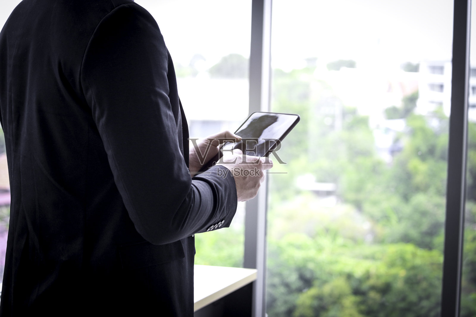 年轻聪明的商人在办公室站立使用智能手机的肖像照片摄影图片