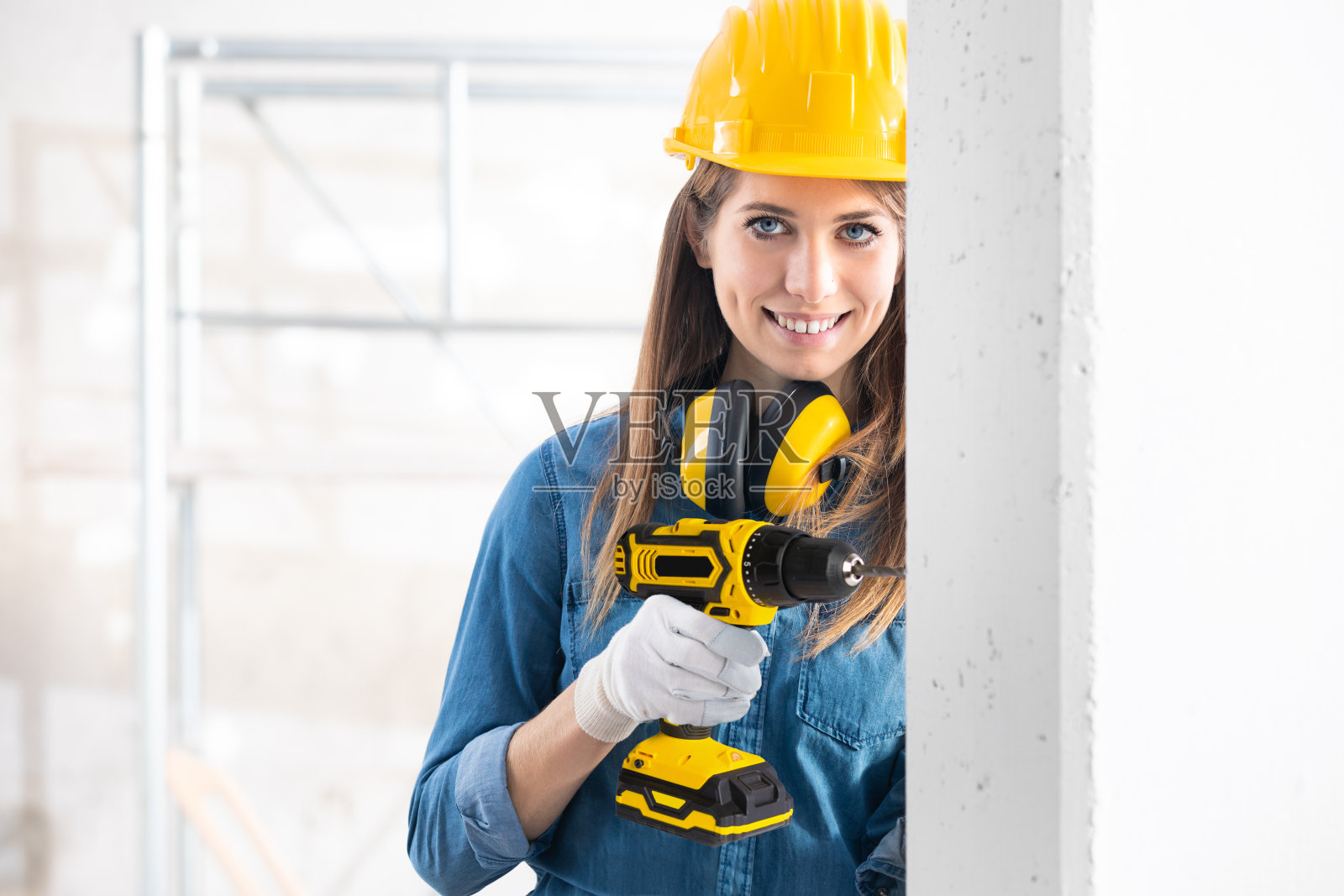 迷人的女性建筑工人钻孔照片摄影图片