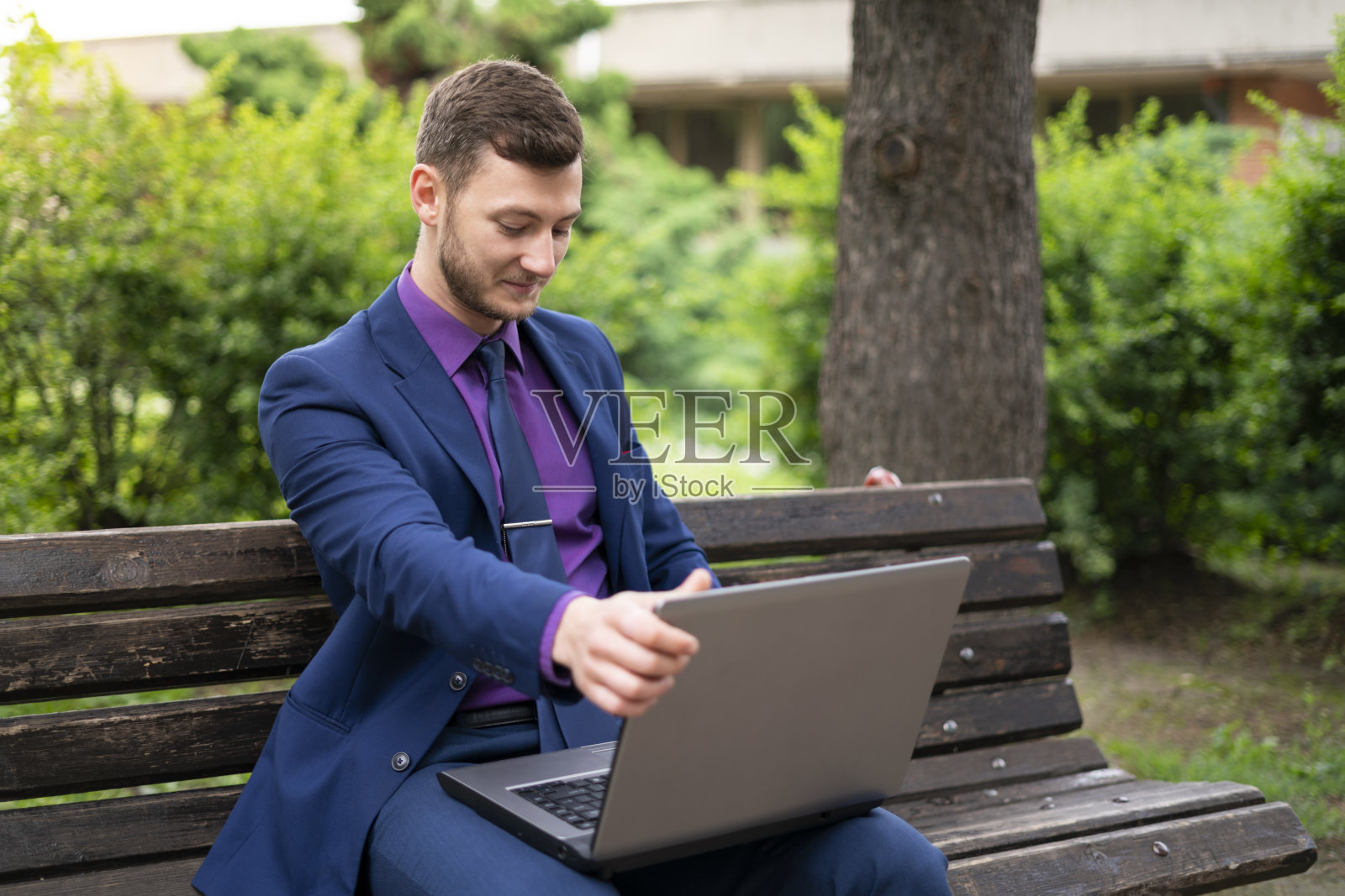 穿着蓝色西装的年轻商人打开他的笔记本电脑照片摄影图片