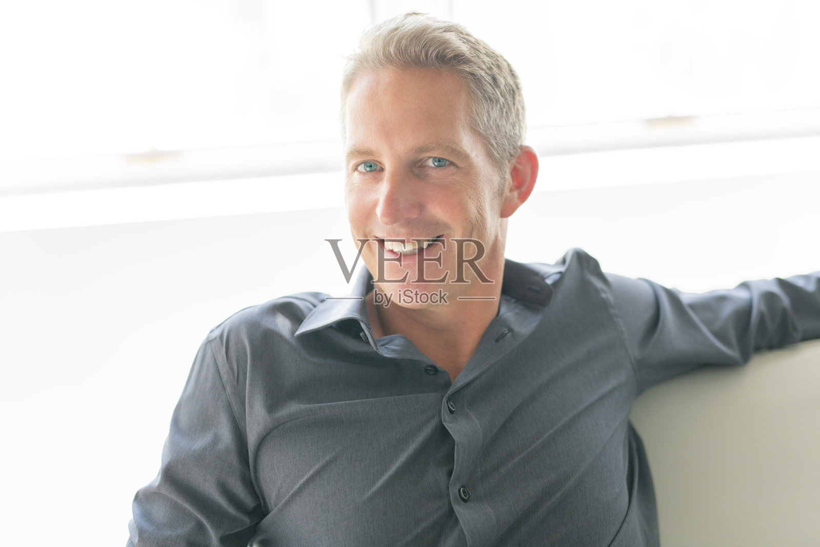 40多岁的单身男人坐在沙发上的肖像照片摄影图片