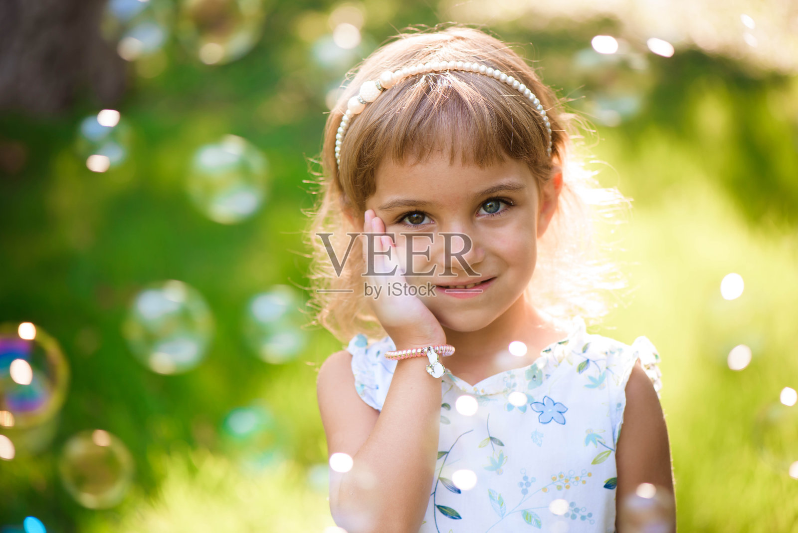 甜美，快乐，微笑的五岁小女孩躺在草地上照片摄影图片